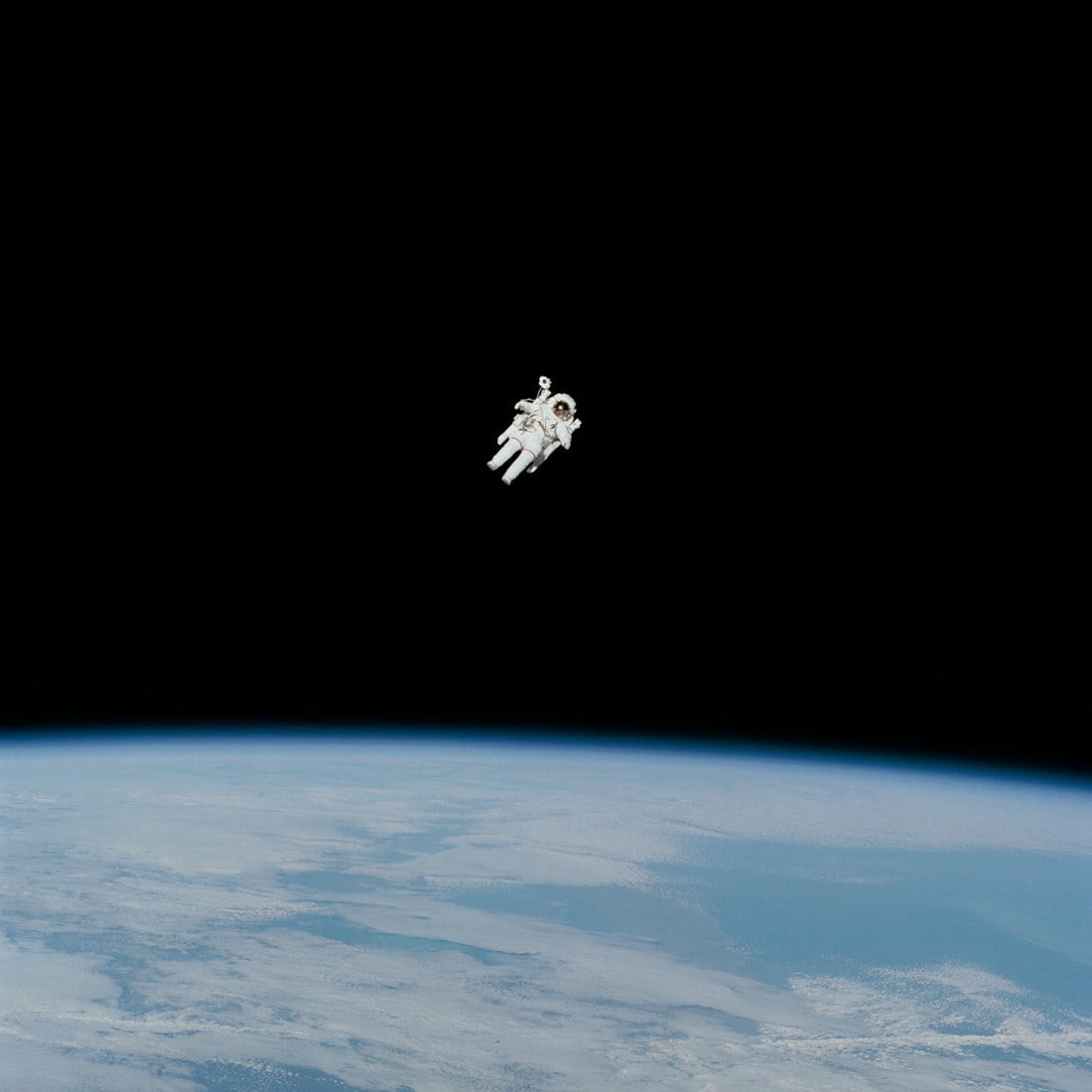 A space explorer floating above the curve of Earth